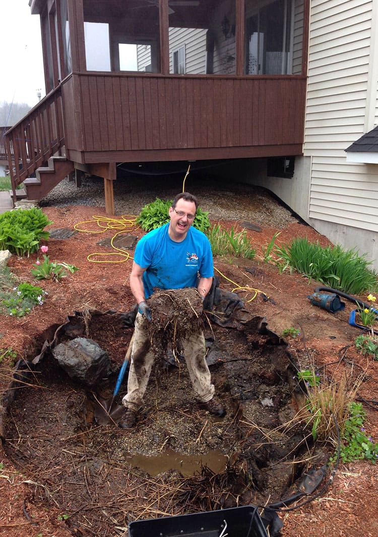 Seasonal pond cleanout in progress on a Massachusetts backyard pond
