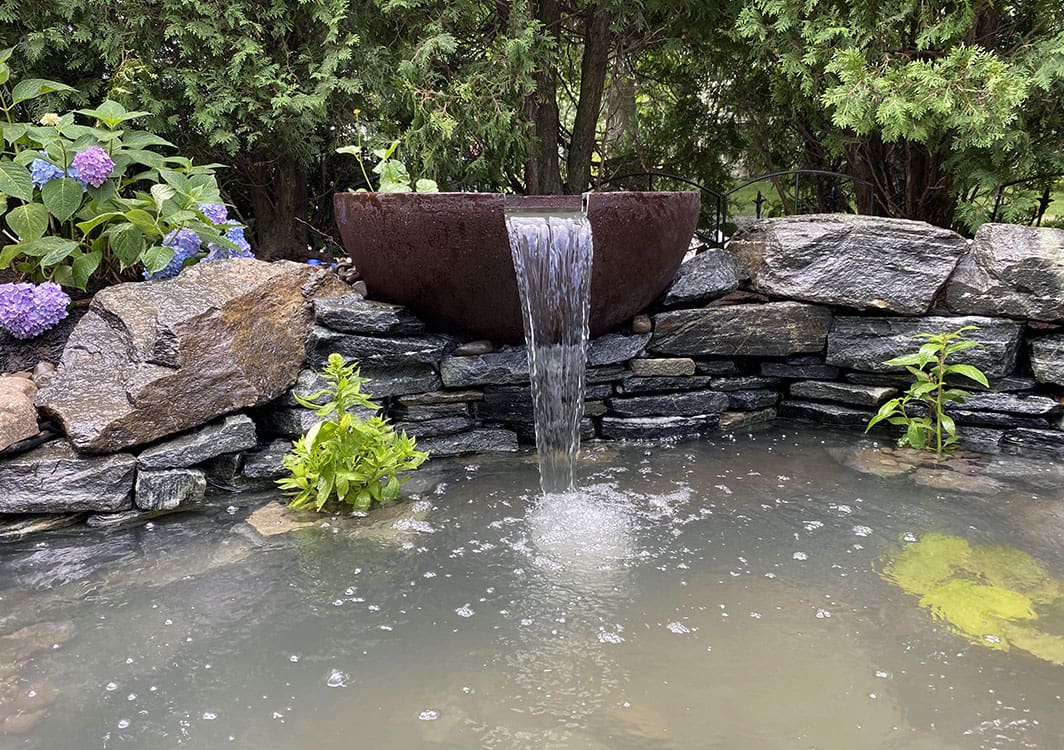 Two sphere fountains paired in a garden setting