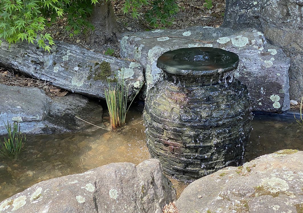 Bubbling rock fountain in a low maintenance garden