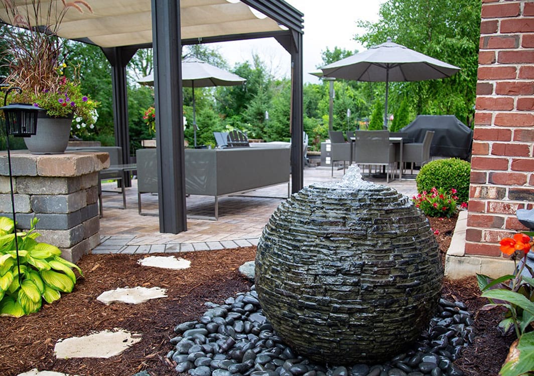 Sphere fountain in a shaded garden corner