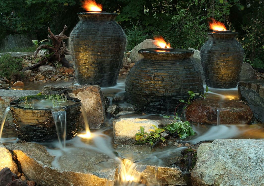 Triple basalt column fountainscape beside a walkway