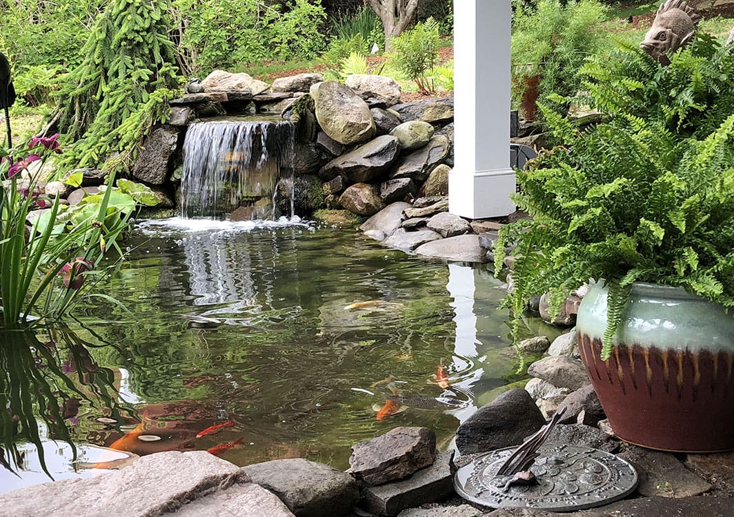 Boulder placement along a curved pond edge during the build