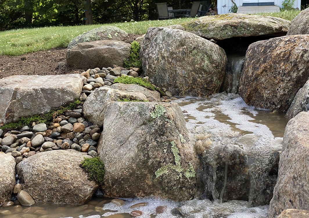 Completed pondless waterfall with mature plantings