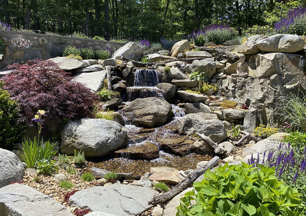 Stream and pondless waterfall crossing a lawn edge