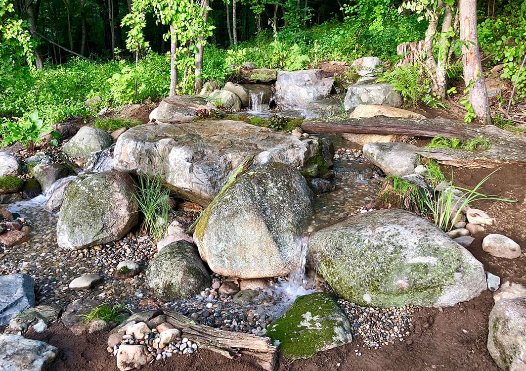 Backyard pondless waterfall with landscape lighting