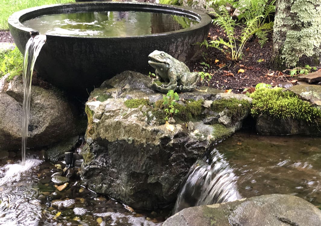 Pondless stream winding through a planted garden bed
