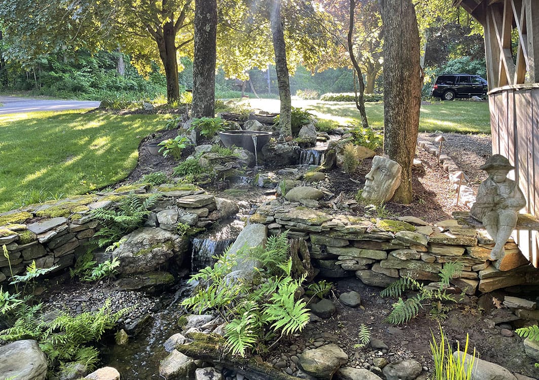 Disappearing waterfall built into a sloped side yard