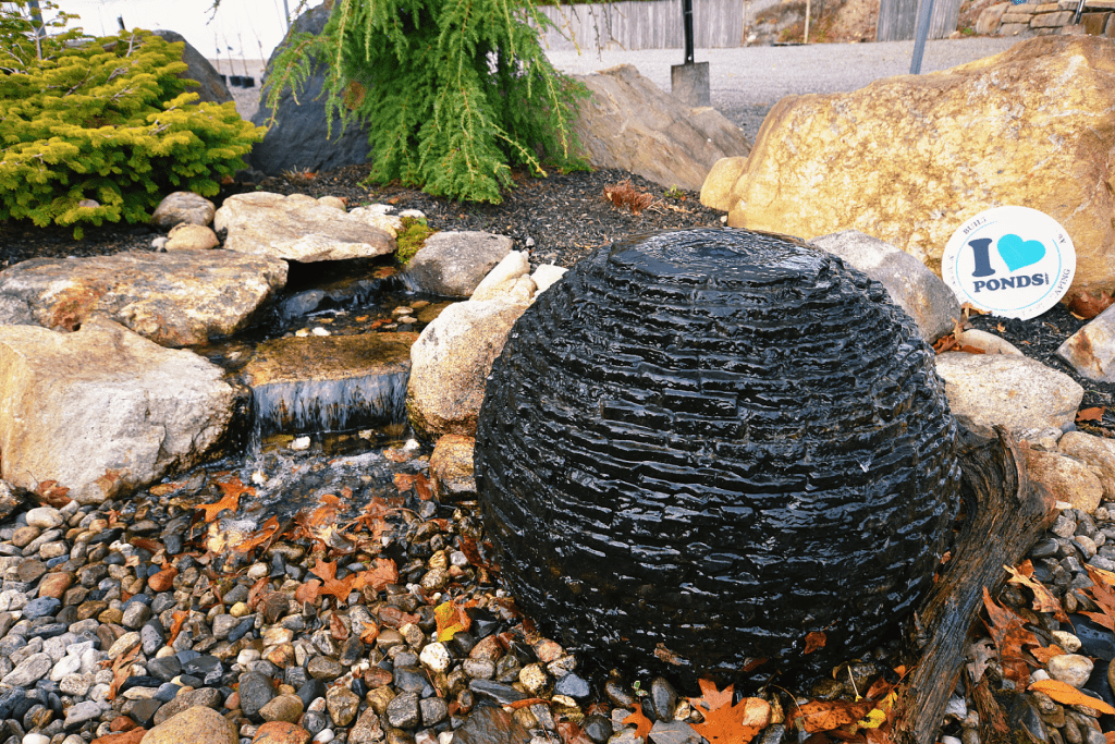 Rock water feature in garden with sign "I love ponds".