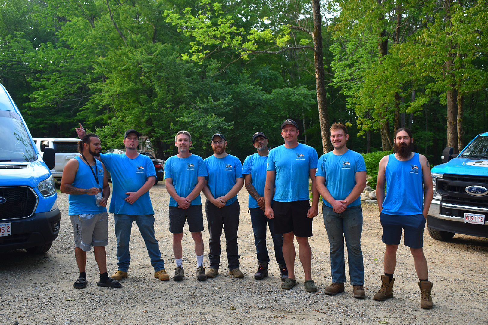 Group of men in blue shirts outdoors.
